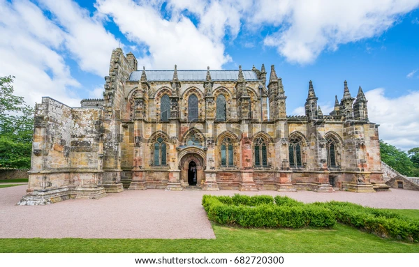 Exterior view of Rosslyn Chapel in Roslin, Scotland, showing Gothic architecture and detailed stonework.